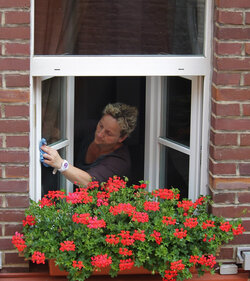Frau putzt Fenster